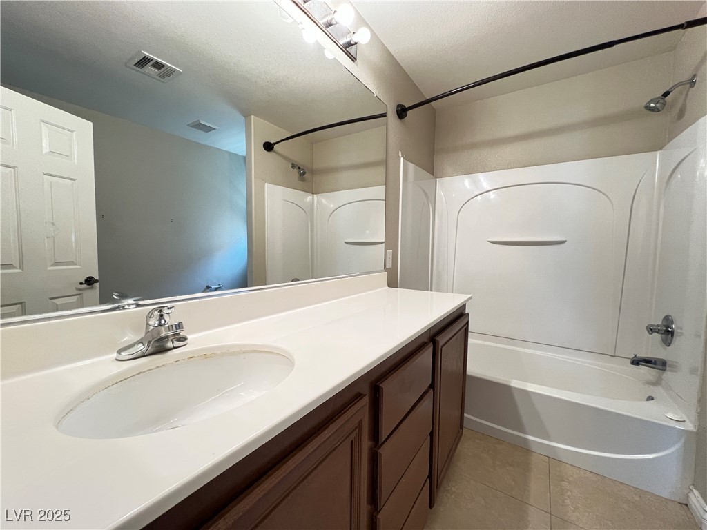8708 Palomino Ranch Street Las Vegas, NV 89131 - Photo 12 of 19 Bathroom featuring tile patterned flooring, washtub / shower combination, vanity, and a textured ceiling