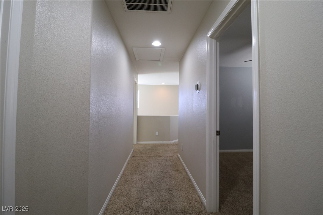 8708 Palomino Ranch Street Las Vegas, NV 89131 - Photo 13 of 19 Corridor featuring a textured wall, attic access, light colored carpet, and recessed lighting