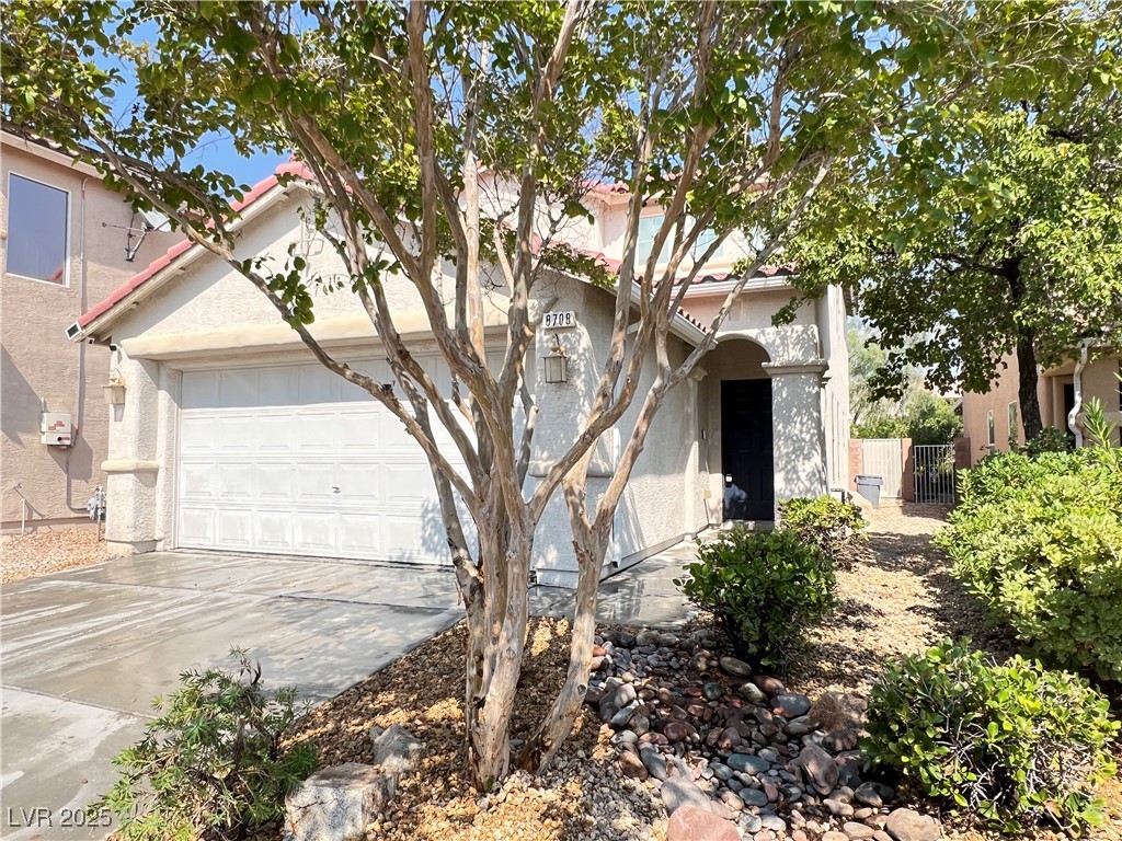 8708 Palomino Ranch Street Las Vegas, NV 89131 - Photo 18 of 19 Mediterranean / spanish home featuring an attached garage, driveway, stucco siding, and a tile roof