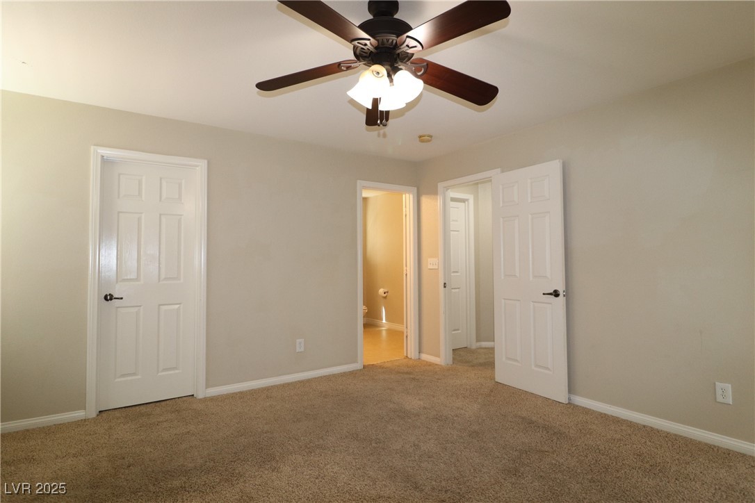 8708 Palomino Ranch Street Las Vegas, NV 89131 - Photo 8 of 19 Unfurnished bedroom featuring carpet flooring, a ceiling fan, and connected bathroom
