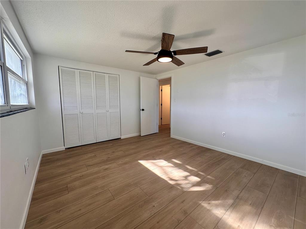 7521 Bougenville Drive Port Richey, FL 34668 - Photo 5 of 9 a view of empty room with wooden floor and fan