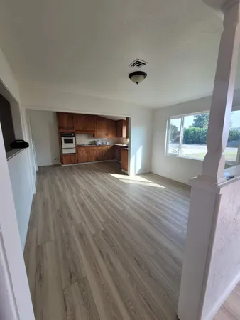 a view of empty room with wooden floor and fireplace