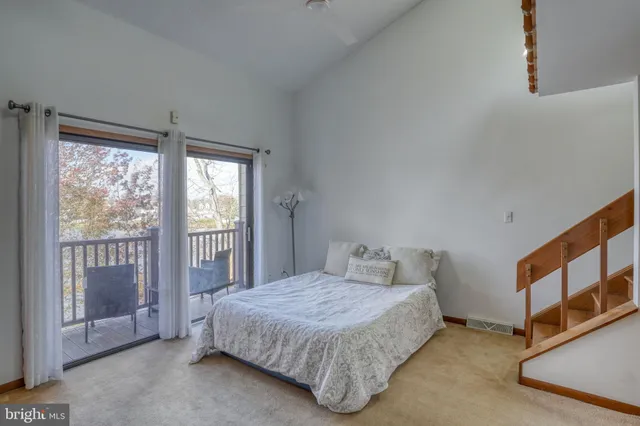 a bedroom with a balcony a bed and a window