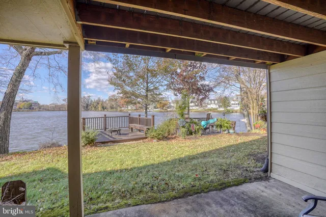 a large body of water next to a building with large trees