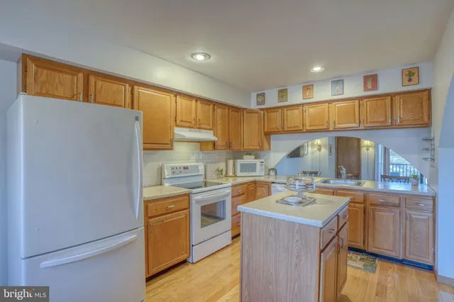 a kitchen with granite countertop a sink a stove and cabinets
