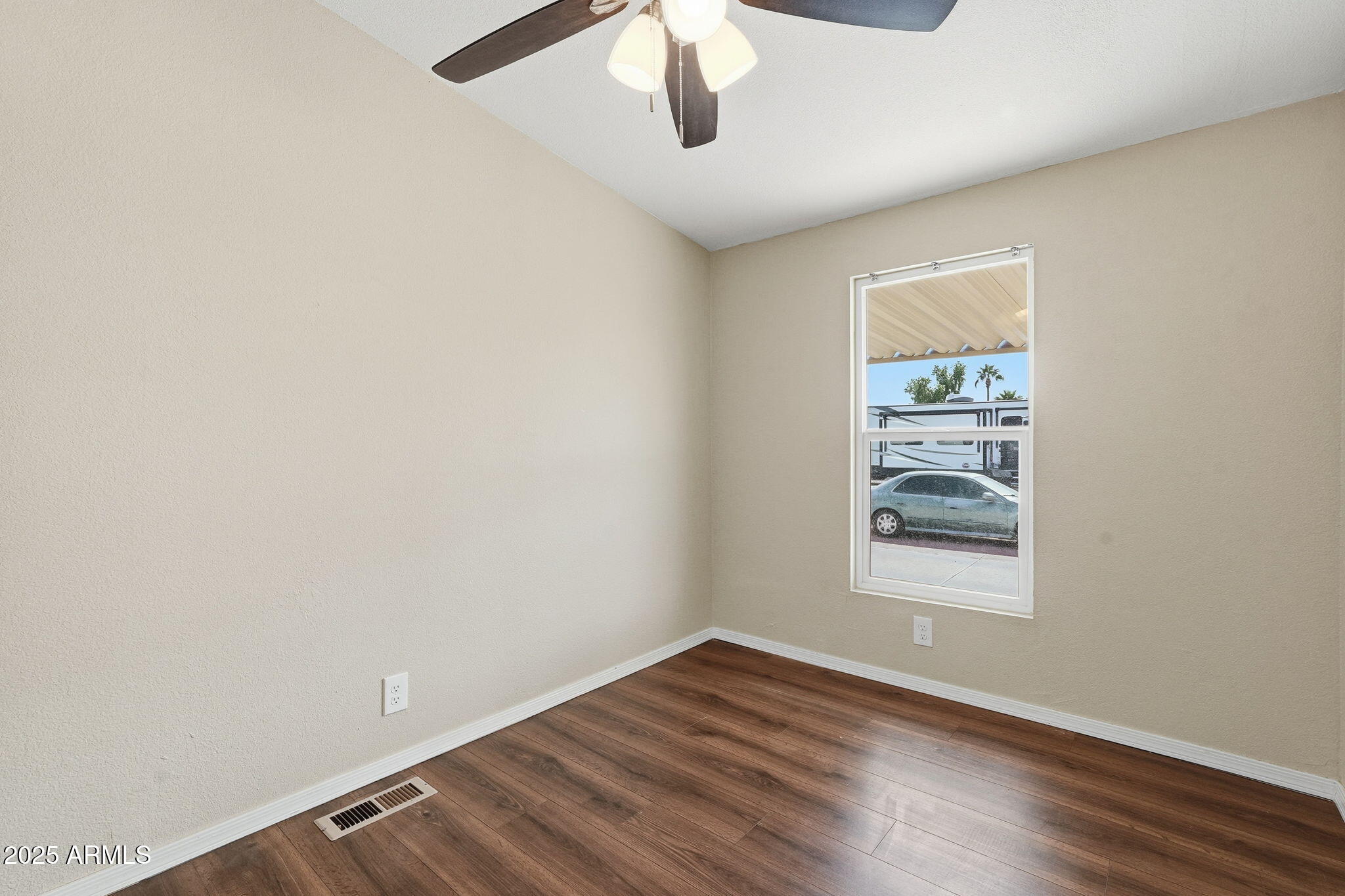 320 East McKellips Road, Unit 166 Mesa, AZ 85201 - Photo 14 of 24 an empty room with wooden floor cabinet and windows