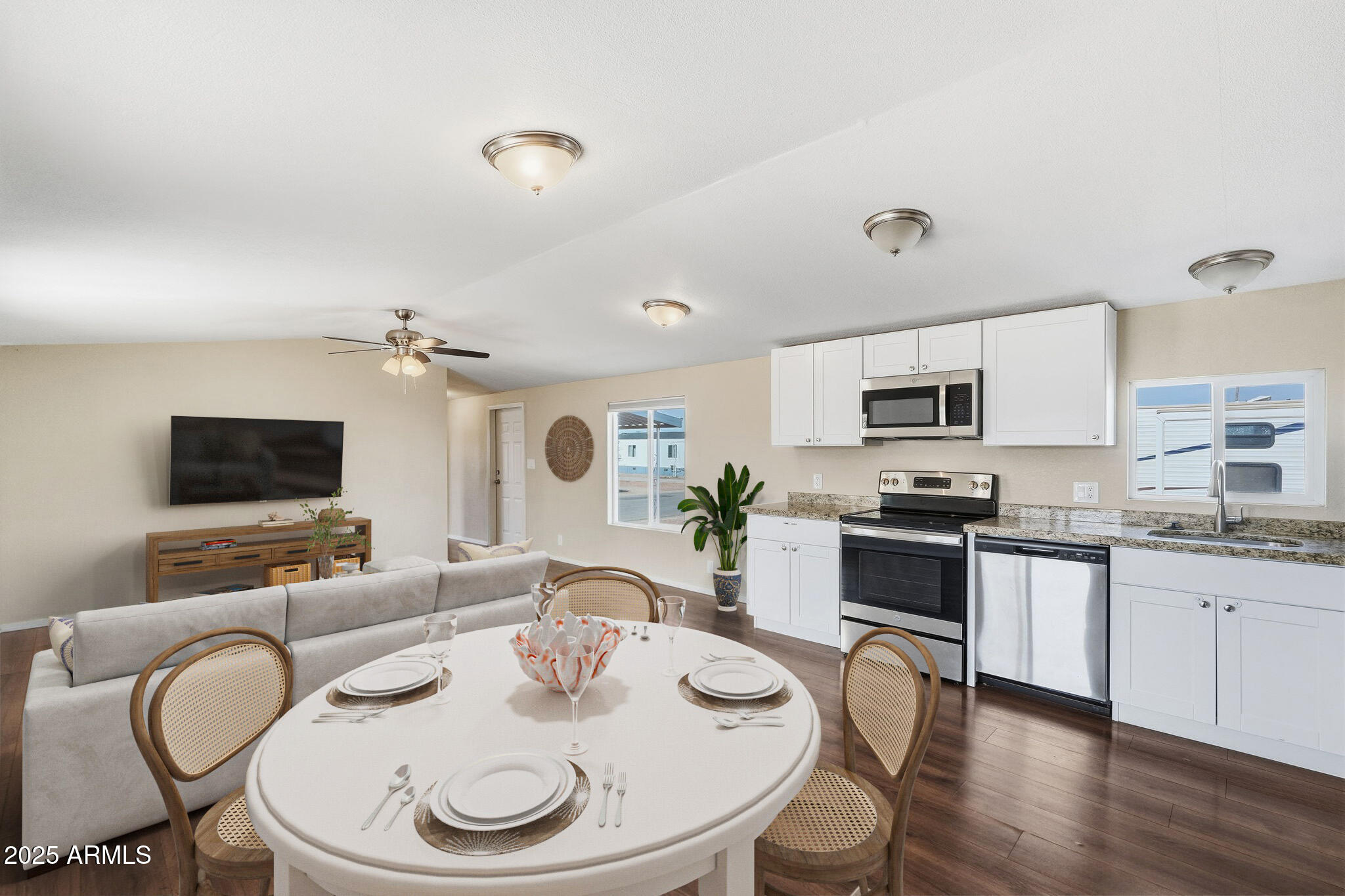 320 East McKellips Road, Unit 166 Mesa, AZ 85201 - Photo 4 of 24 a kitchen with stainless steel appliances kitchen island granite countertop a stove a sink a dining table and chairs