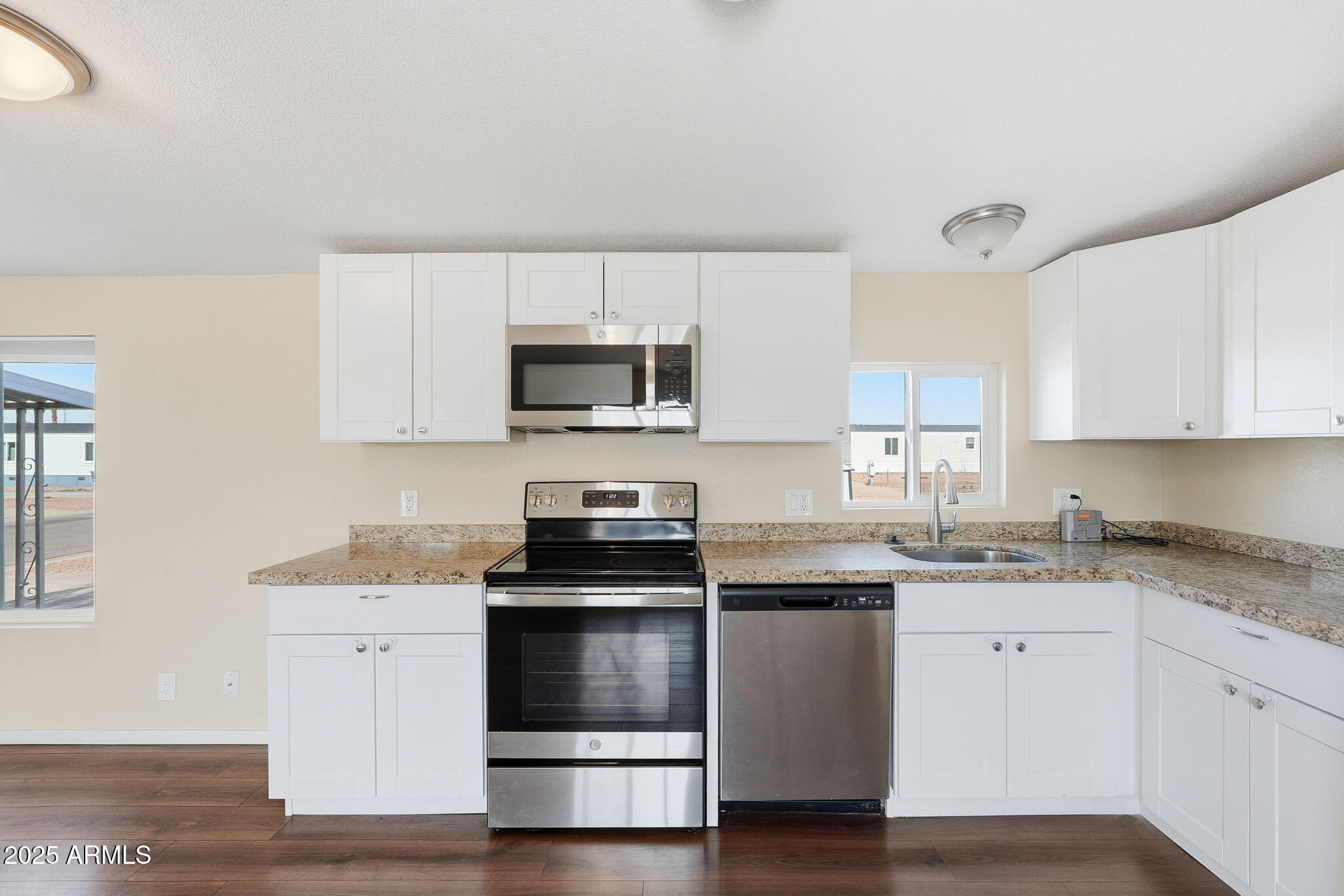 320 East McKellips Road, Unit 166 Mesa, AZ 85201 - Photo 5 of 24 a kitchen with cabinets stainless steel appliances a sink and a window