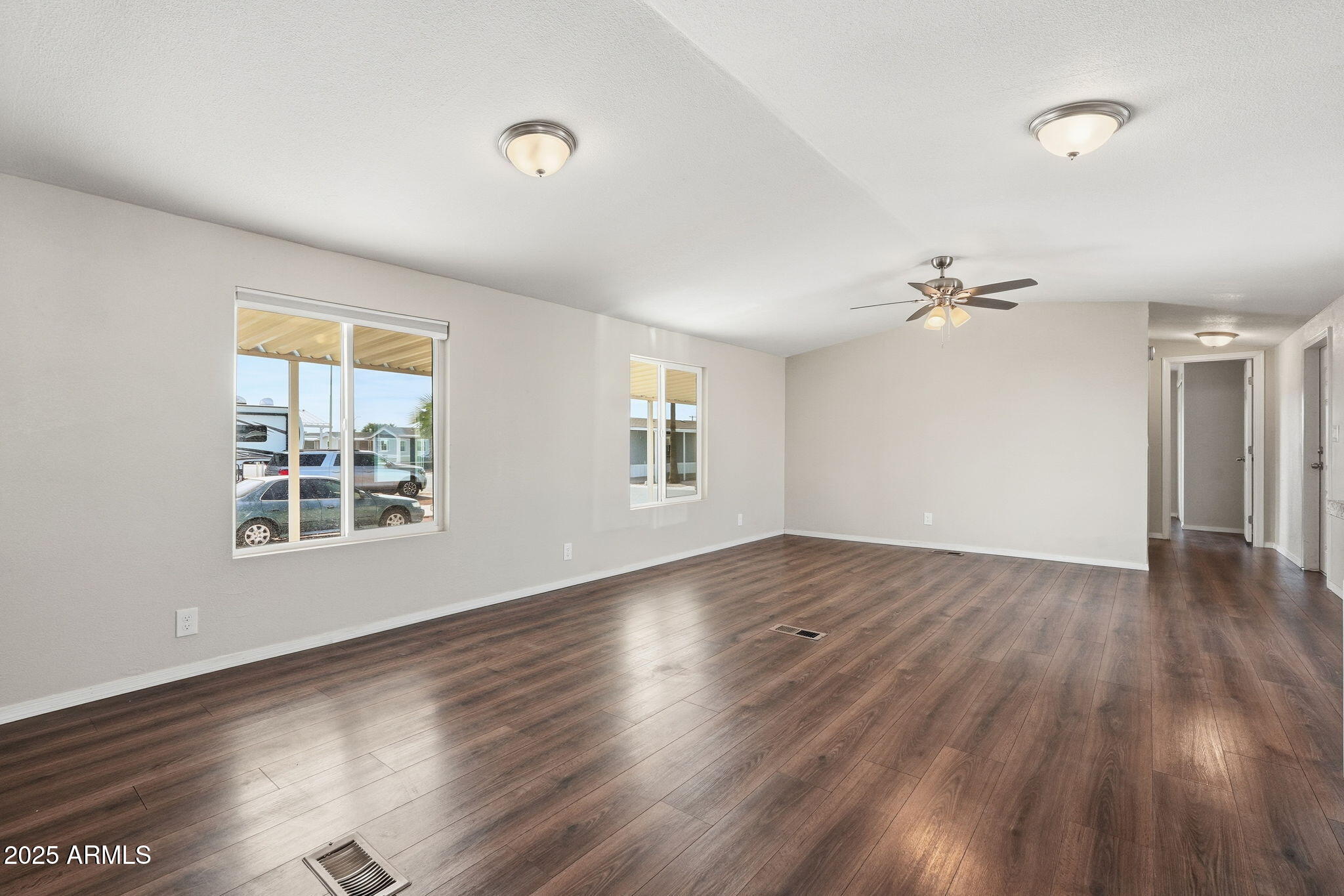 320 East McKellips Road, Unit 166 Mesa, AZ 85201 - Photo 8 of 24 an empty room with wooden floor and windows