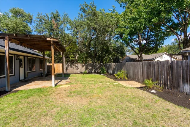 a backyard with table and chairs and wooden fence