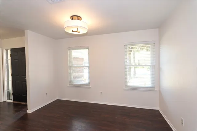 an empty room with wooden floor and a window