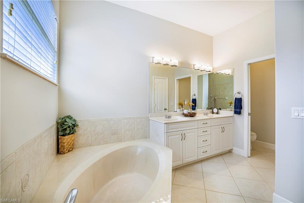 5235 Malvern Court Naples, FL 34112 - Photo 17 of 28 a bathroom with a tub sink and mirror
