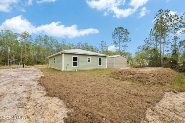 a view of a house with backyard and sitting area