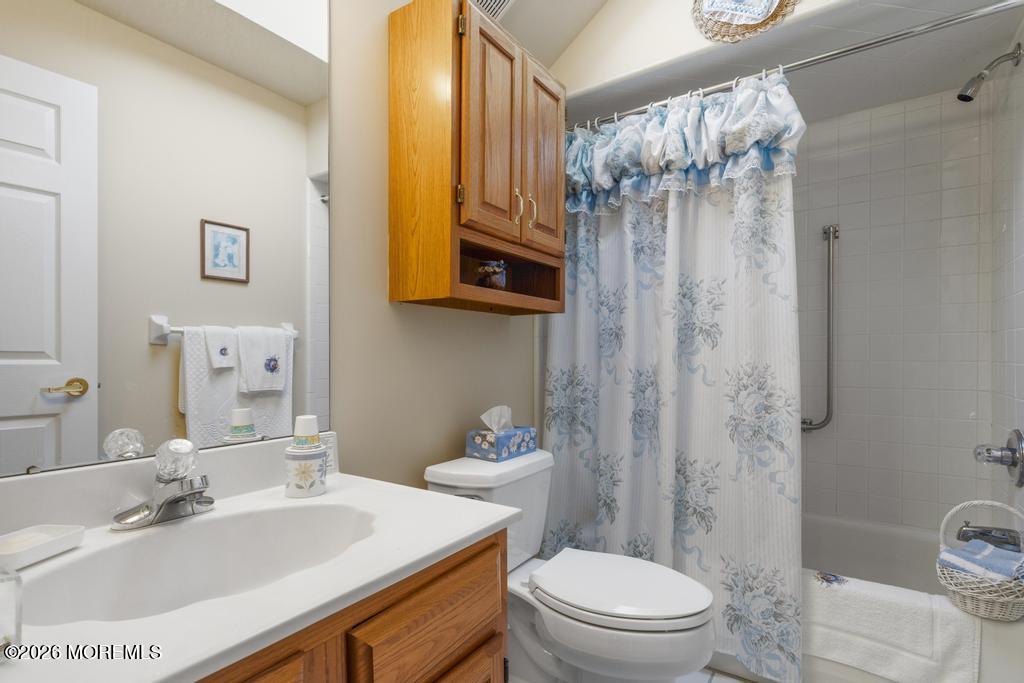 2287 Coral Leaf Road Toms River, NJ 08755 - Photo 36 of 38 a bathroom with a sink a toilet and shower curtain
