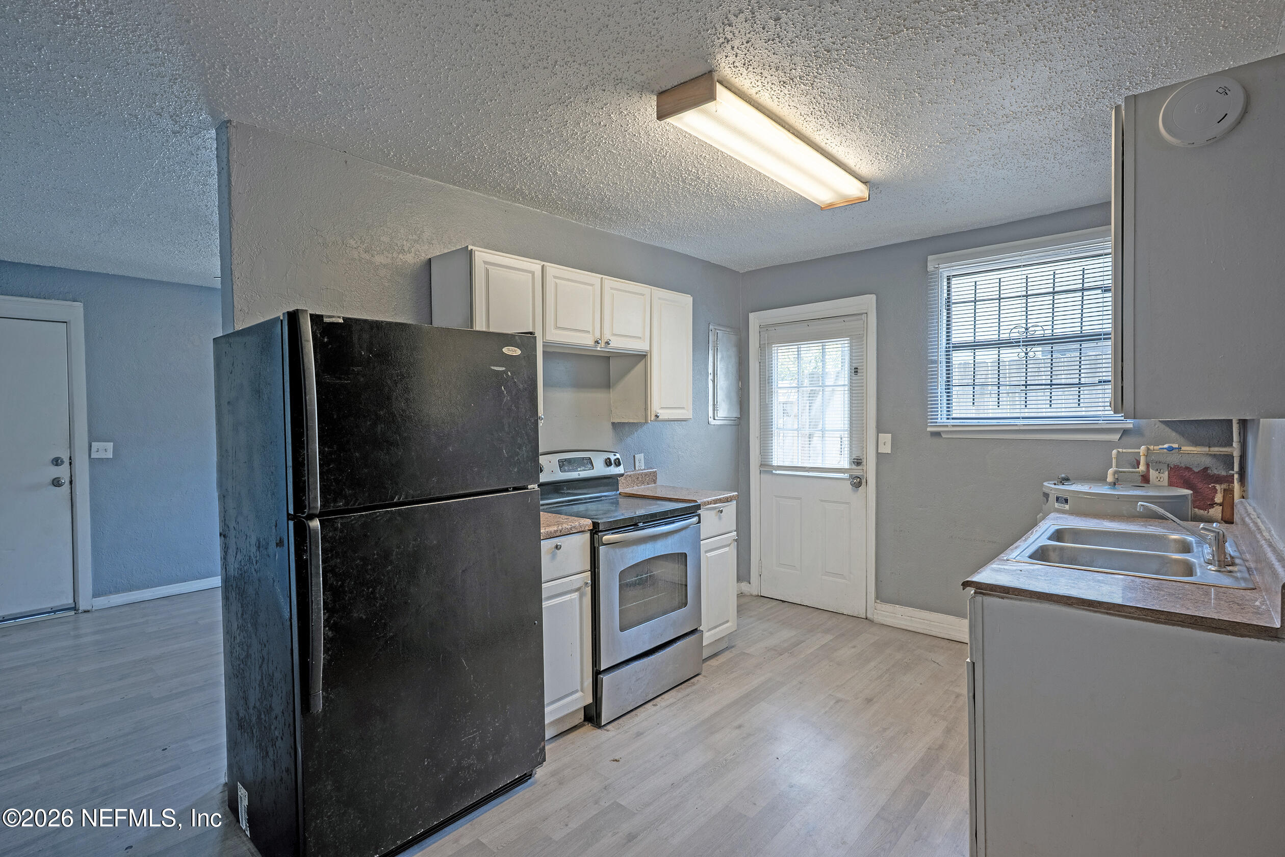4114 Moncrief Road Jacksonville, FL 32209 - Photo 11 of 42 a kitchen with a refrigerator sink and cabinets