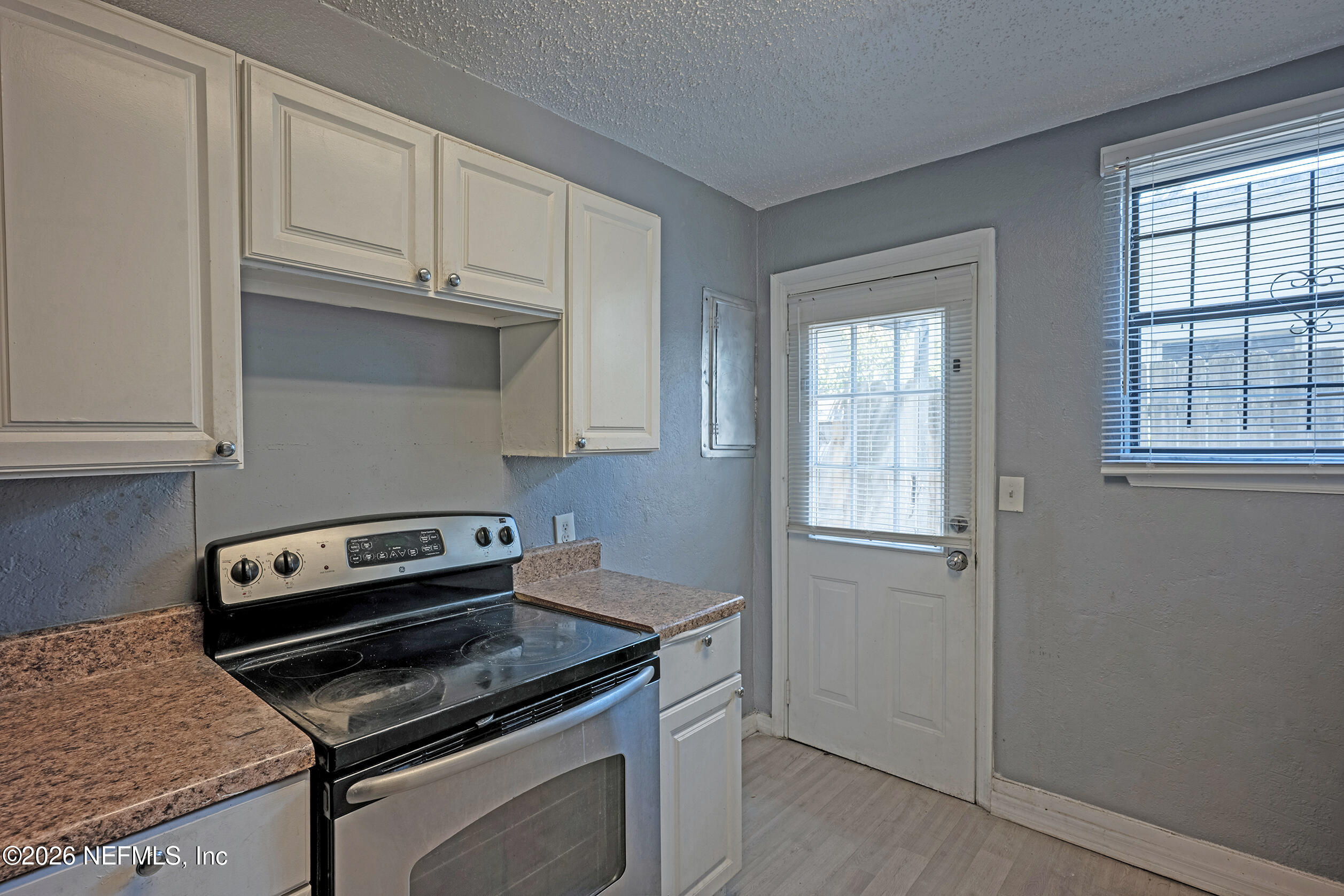 4114 Moncrief Road Jacksonville, FL 32209 - Photo 14 of 42 a kitchen with granite countertop white cabinets and appliances