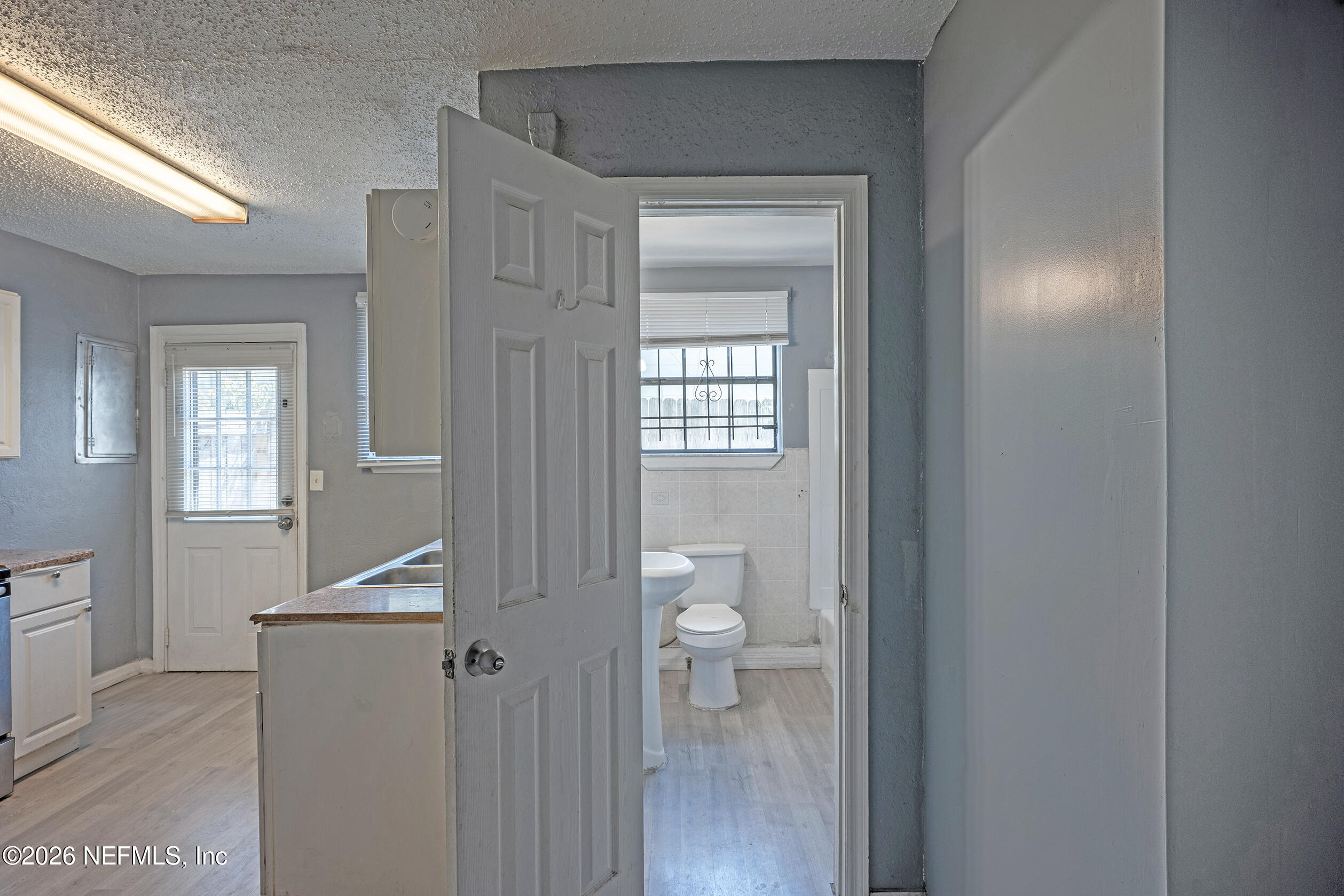 4114 Moncrief Road Jacksonville, FL 32209 - Photo 16 of 42 a view of a hallway with bathroom and wooden floor