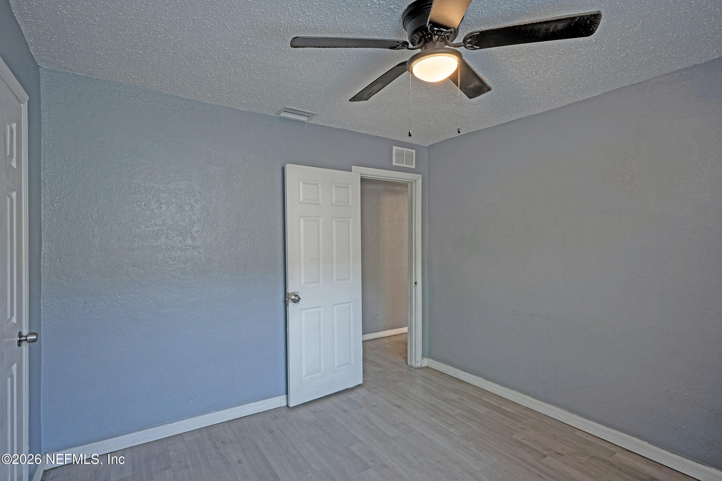 4114 Moncrief Road Jacksonville, FL 32209 - Photo 20 of 42 an empty room with wooden floor a ceiling fan and closet