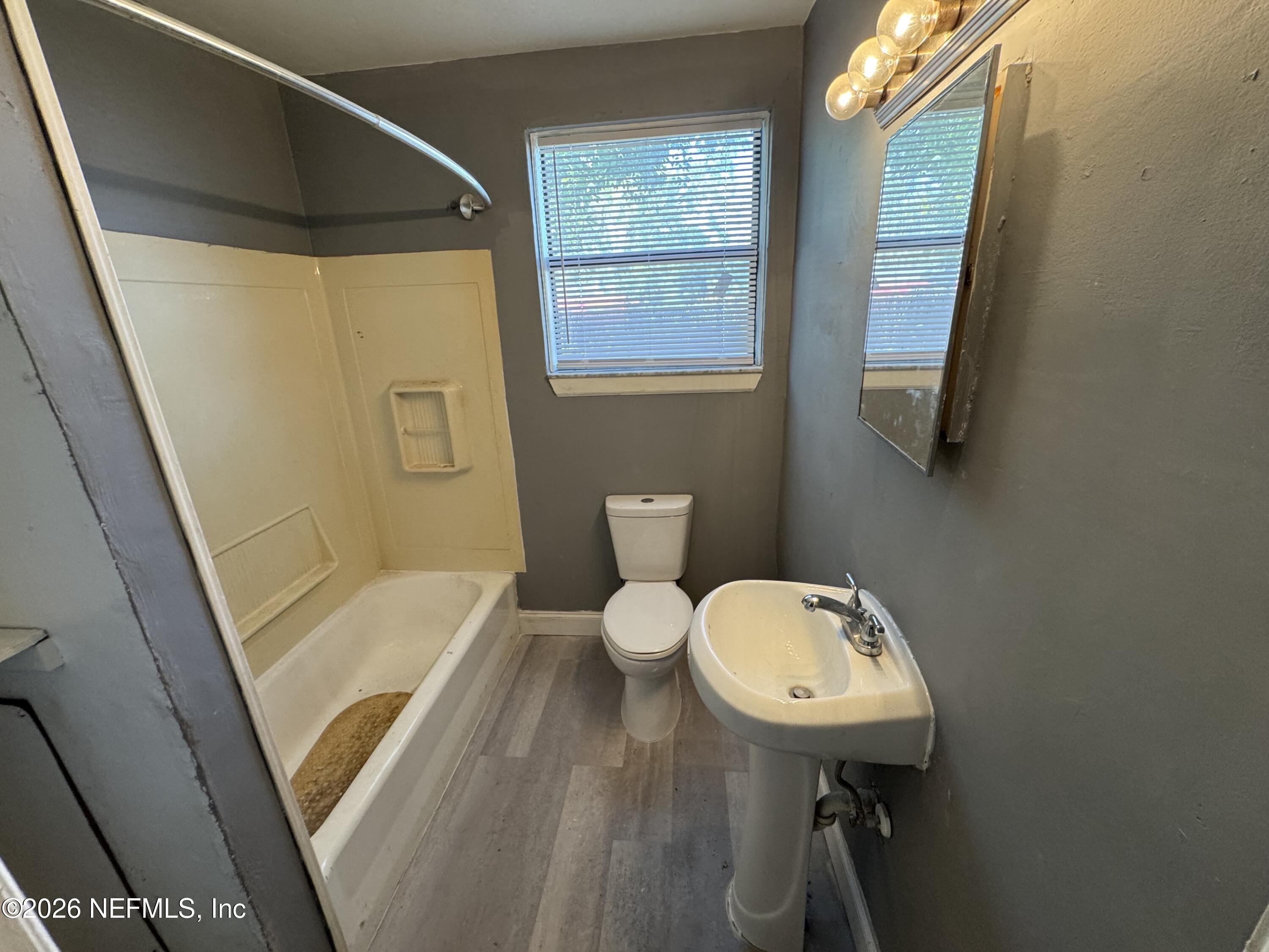 4114 Moncrief Road Jacksonville, FL 32209 - Photo 31 of 42 a bathroom with a sink a toilet a mirror and shower