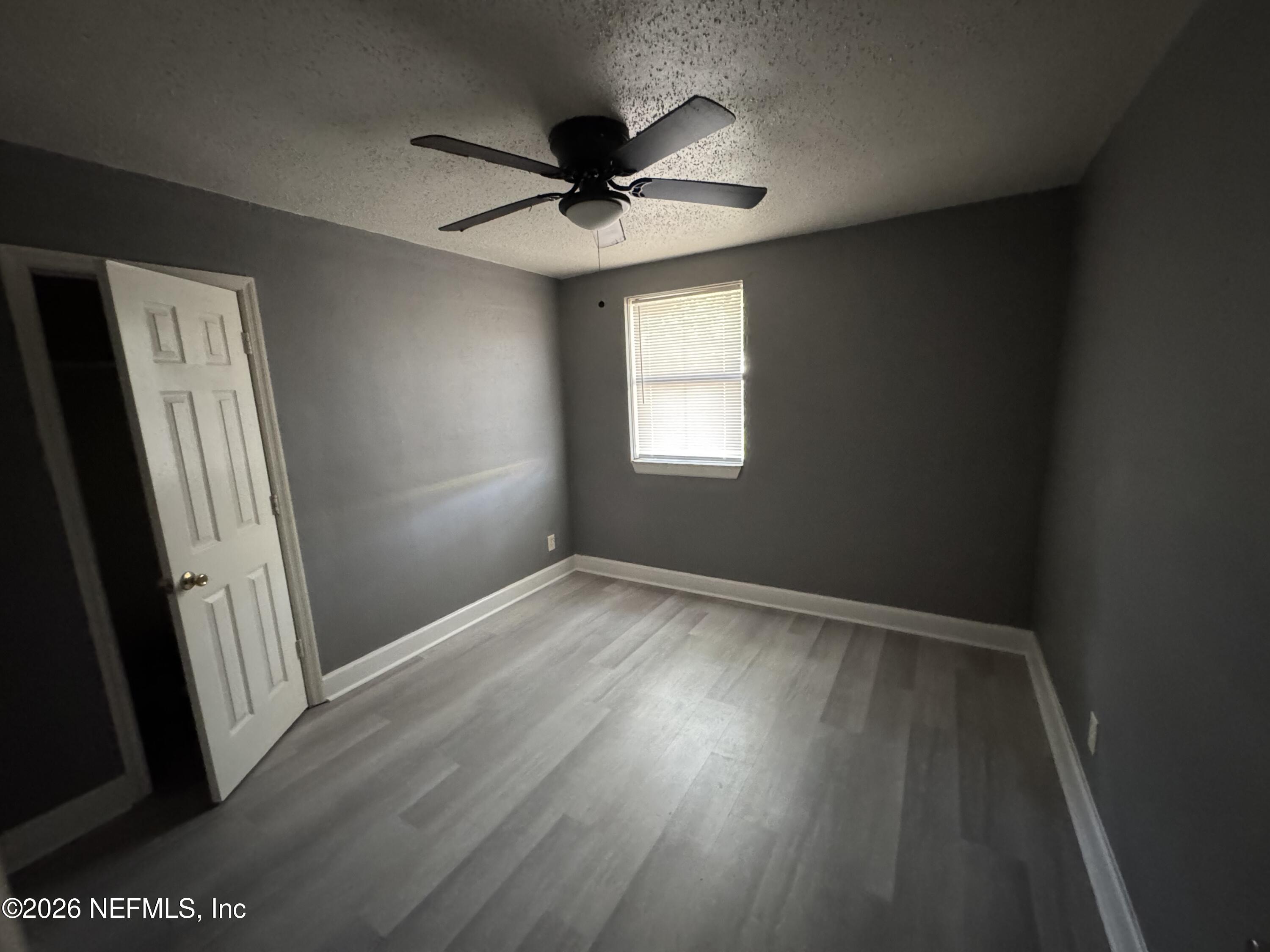 4114 Moncrief Road Jacksonville, FL 32209 - Photo 32 of 42 an empty room with wooden floor and windows