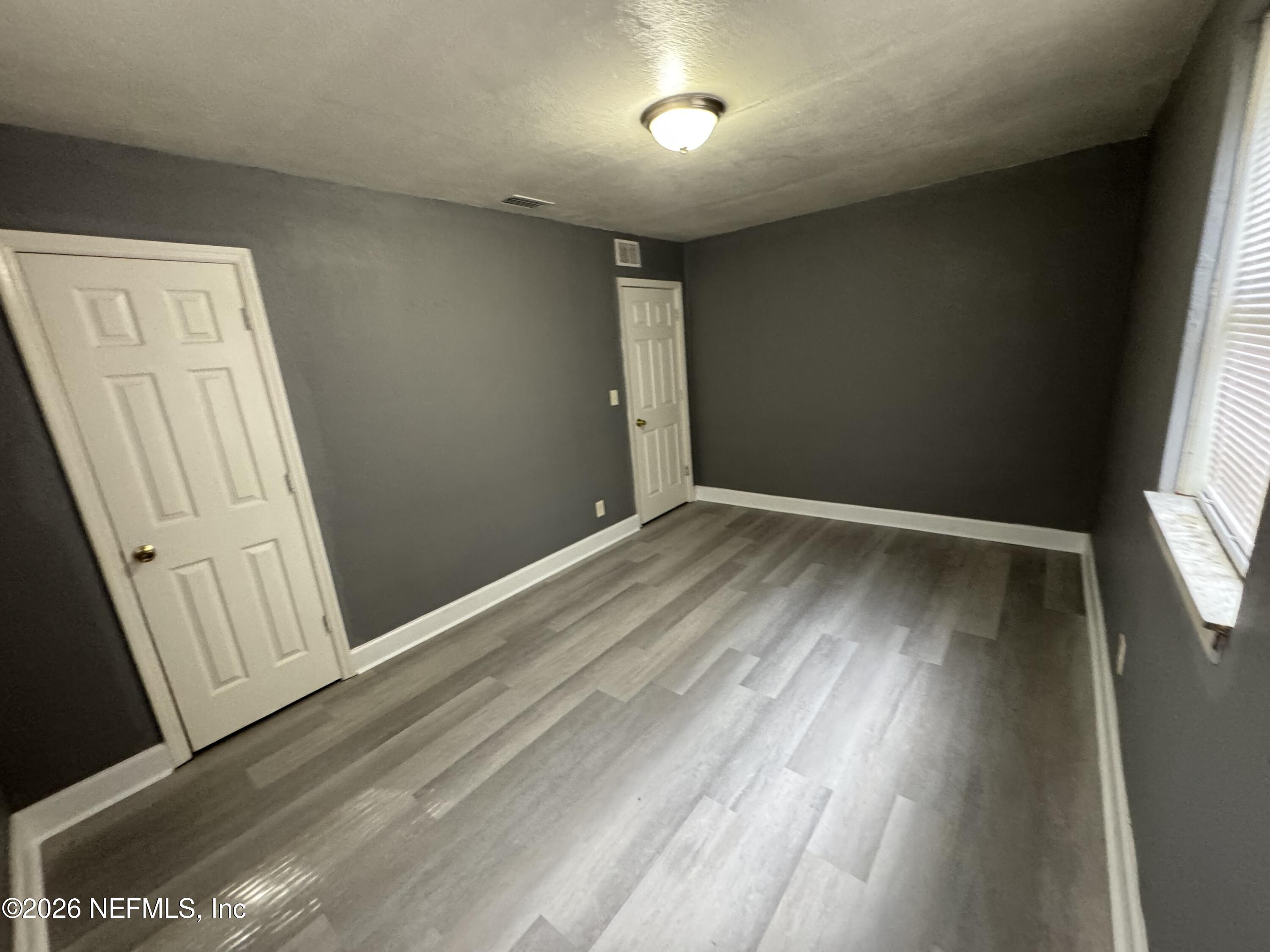 4114 Moncrief Road Jacksonville, FL 32209 - Photo 36 of 42 an empty room with wooden floor and windows