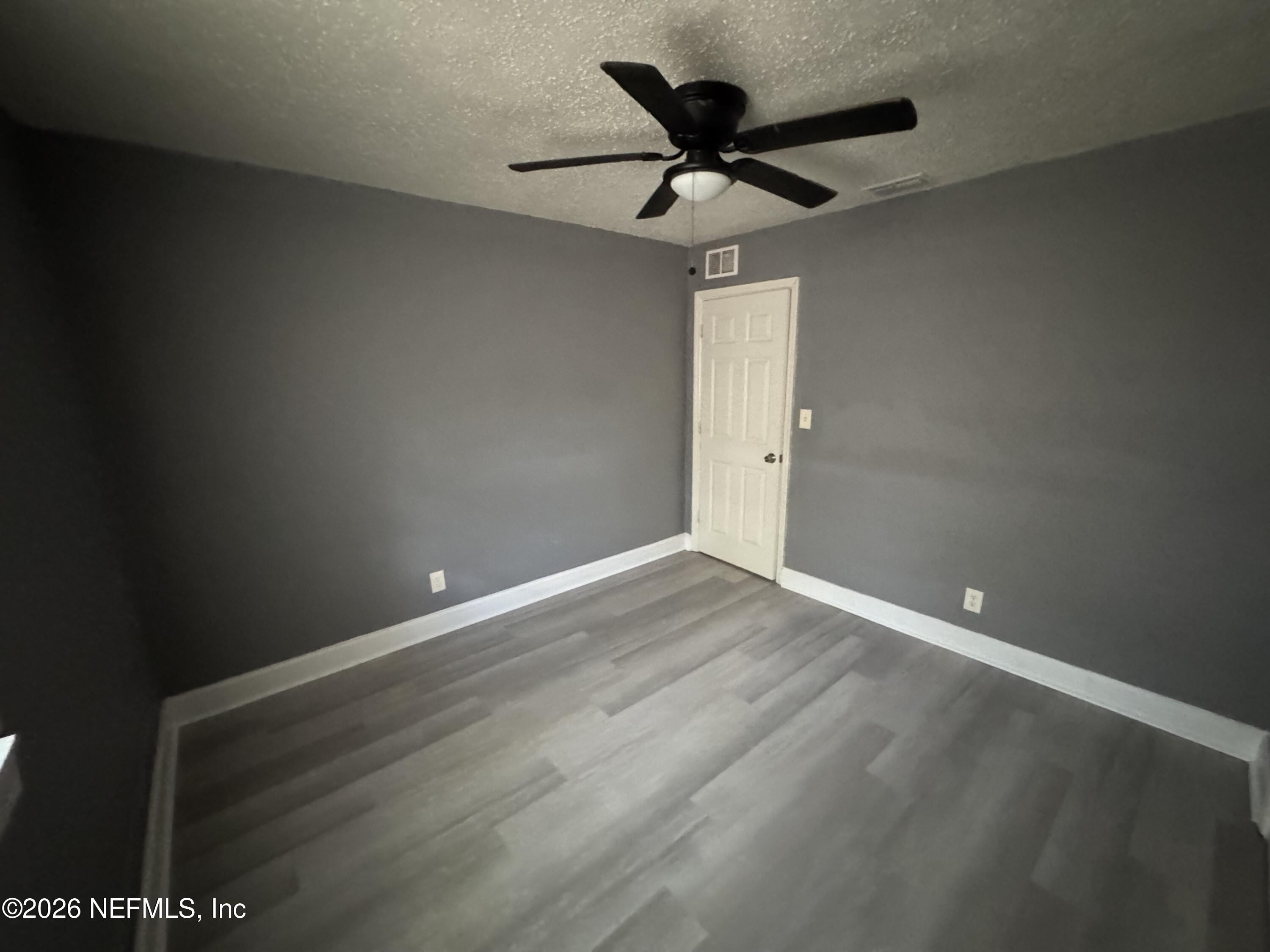 4114 Moncrief Road Jacksonville, FL 32209 - Photo 39 of 42 en empty room with wooden floor and ceiling fan
