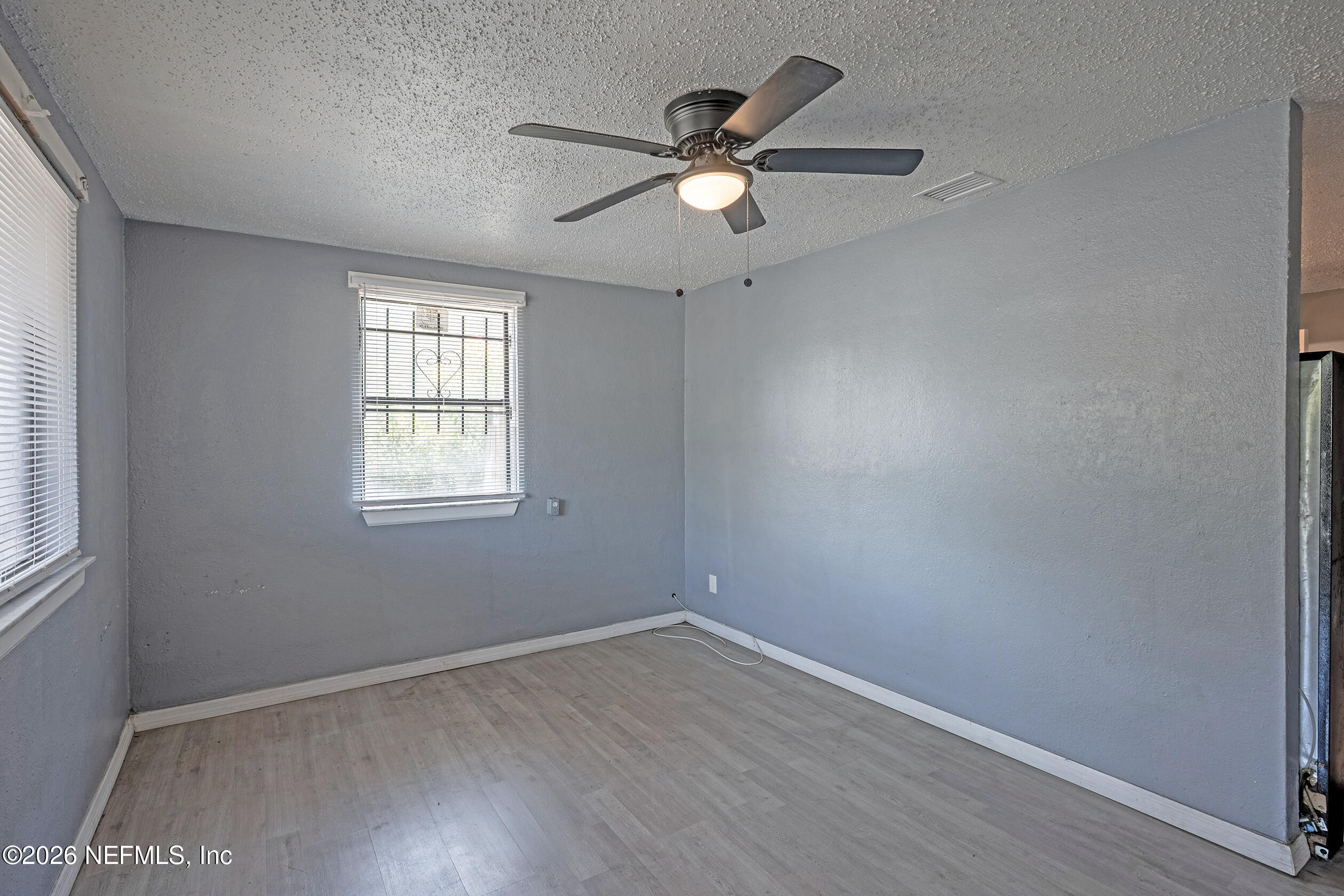 4114 Moncrief Road Jacksonville, FL 32209 - Photo 5 of 42 an empty room with wooden floor fan and windows