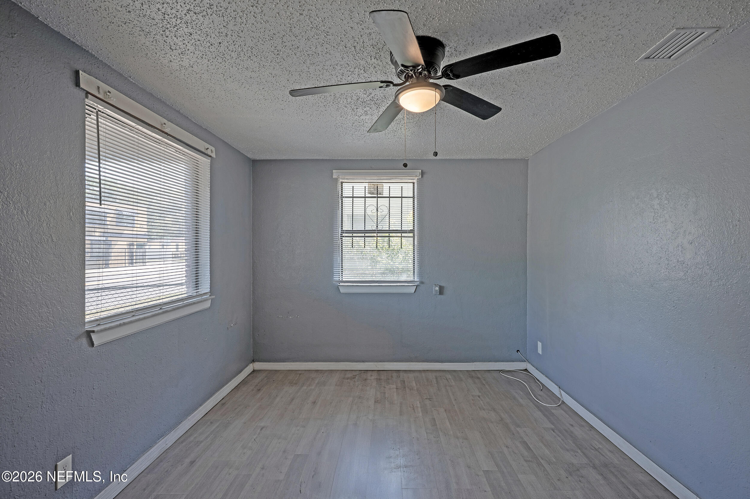 4114 Moncrief Road Jacksonville, FL 32209 - Photo 6 of 42 an empty room with wooden floor fan and windows