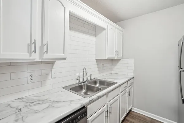 a kitchen with white cabinets a sink and dishwasher