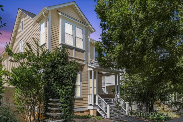 a front view of a house with a tree