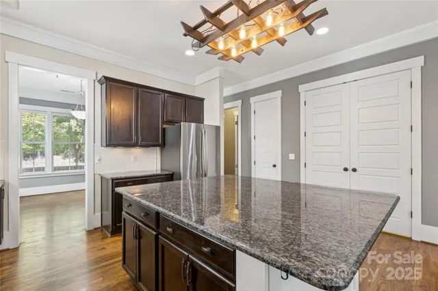 a kitchen with a center island wooden floor and a window