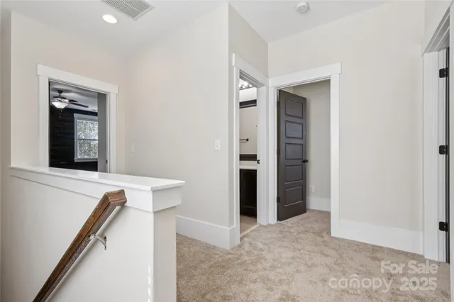 en empty room with windows and chandelier fan