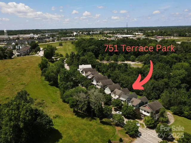 an aerial view of a house with a garden and lake view