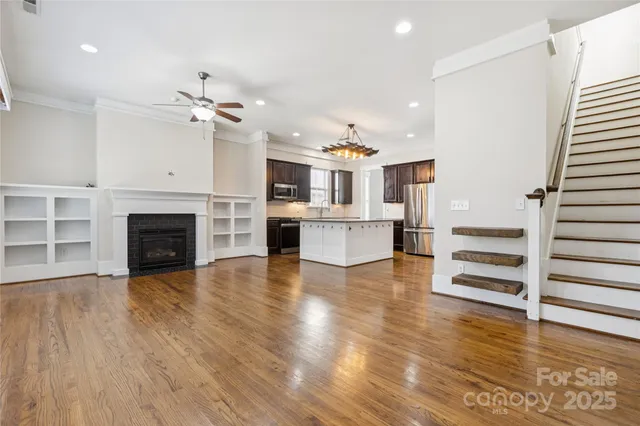 an open kitchen with granite countertop wooden floors and a fireplace
