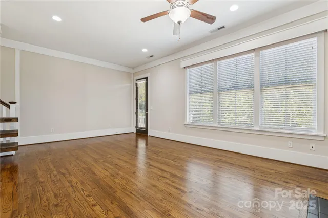 a view of a kitchen with a kitchen island wooden floor and a ceiling fan