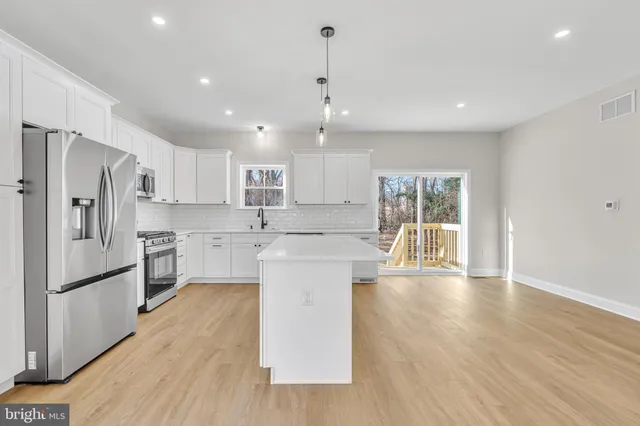 a open kitchen with white cabinets and stainless steel appliances