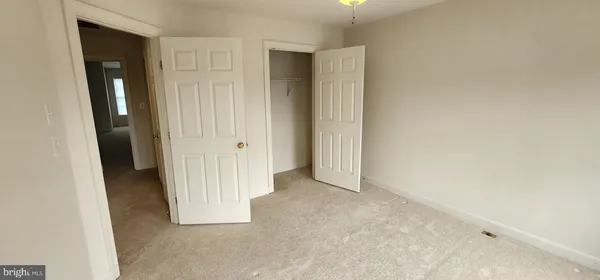 an empty room with windows and closet