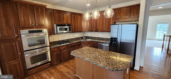 a kitchen with granite countertop wooden cabinets and stainless steel appliances