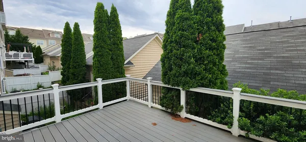 a balcony view with wooden floor and fence in the background