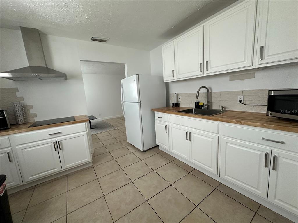 1909 West Green Street Tampa, FL 33607 - Photo 4 of 9 a kitchen with white cabinets and white appliances