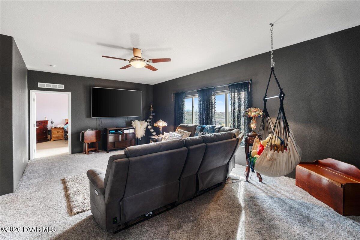8475 West Red Rock Road Kirkland, AZ 86332 - Photo 12 of 39 a living room with furniture a flat screen tv and a ceiling fan