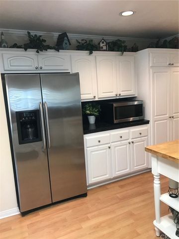 a kitchen with stainless steel appliances granite countertop a table and chairs in it