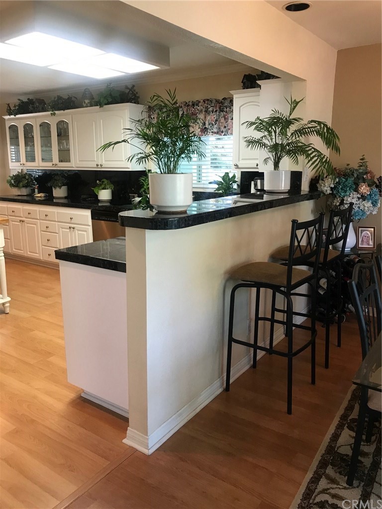 6053 Loynes Drive Long Beach, CA 90803 - Photo 6 of 21 a kitchen with stainless steel appliances granite countertop a table and chairs in it