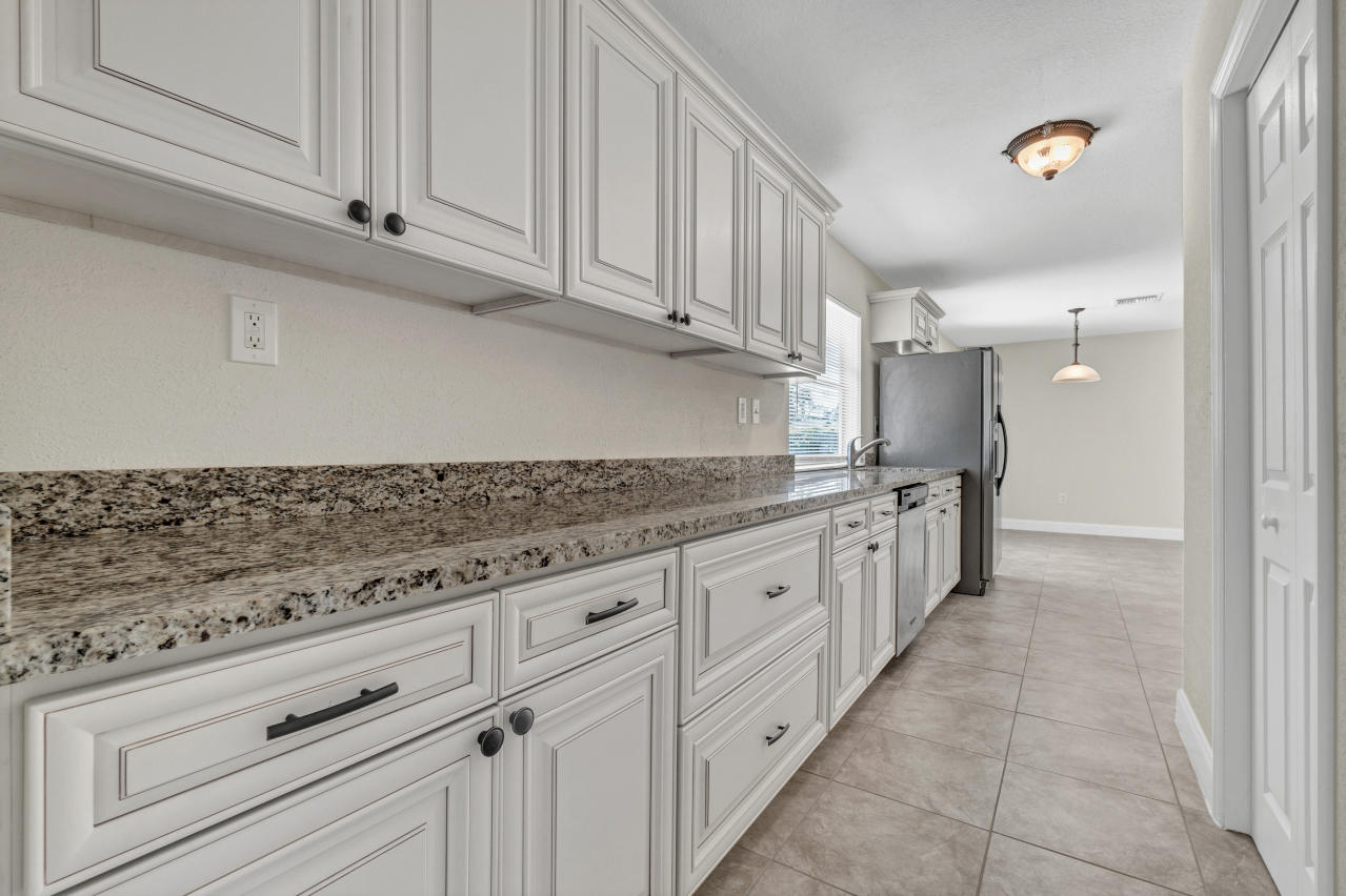 3526 Ivanhoe Avenue Boynton Beach, FL 33436 - Photo 11 of 29 a kitchen with granite countertop white cabinets and stainless steel appliances