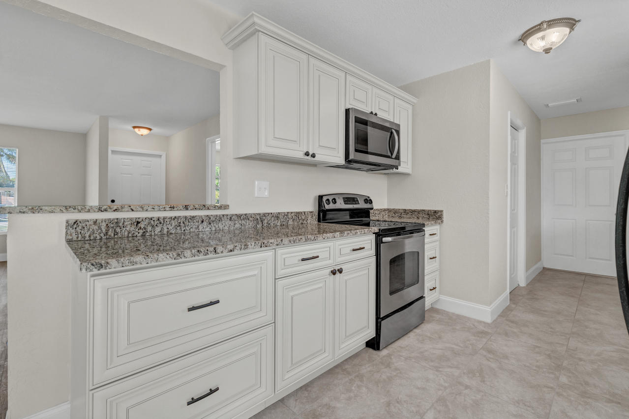 3526 Ivanhoe Avenue Boynton Beach, FL 33436 - Photo 12 of 29 a kitchen with white cabinets stainless steel appliances and sink