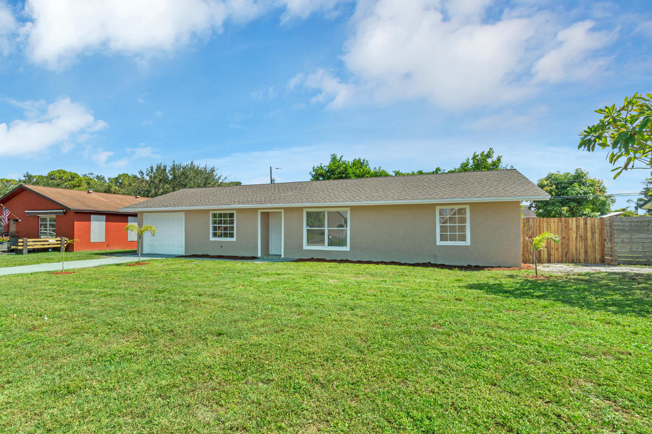 3526 Ivanhoe Avenue Boynton Beach, FL 33436 - Photo 3 of 29 a view of a yard in front of a house with plants and large tree