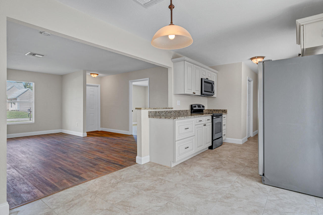 3526 Ivanhoe Avenue Boynton Beach, FL 33436 - Photo 10 of 29 a kitchen with stainless steel appliances granite countertop a refrigerator and a stove top oven