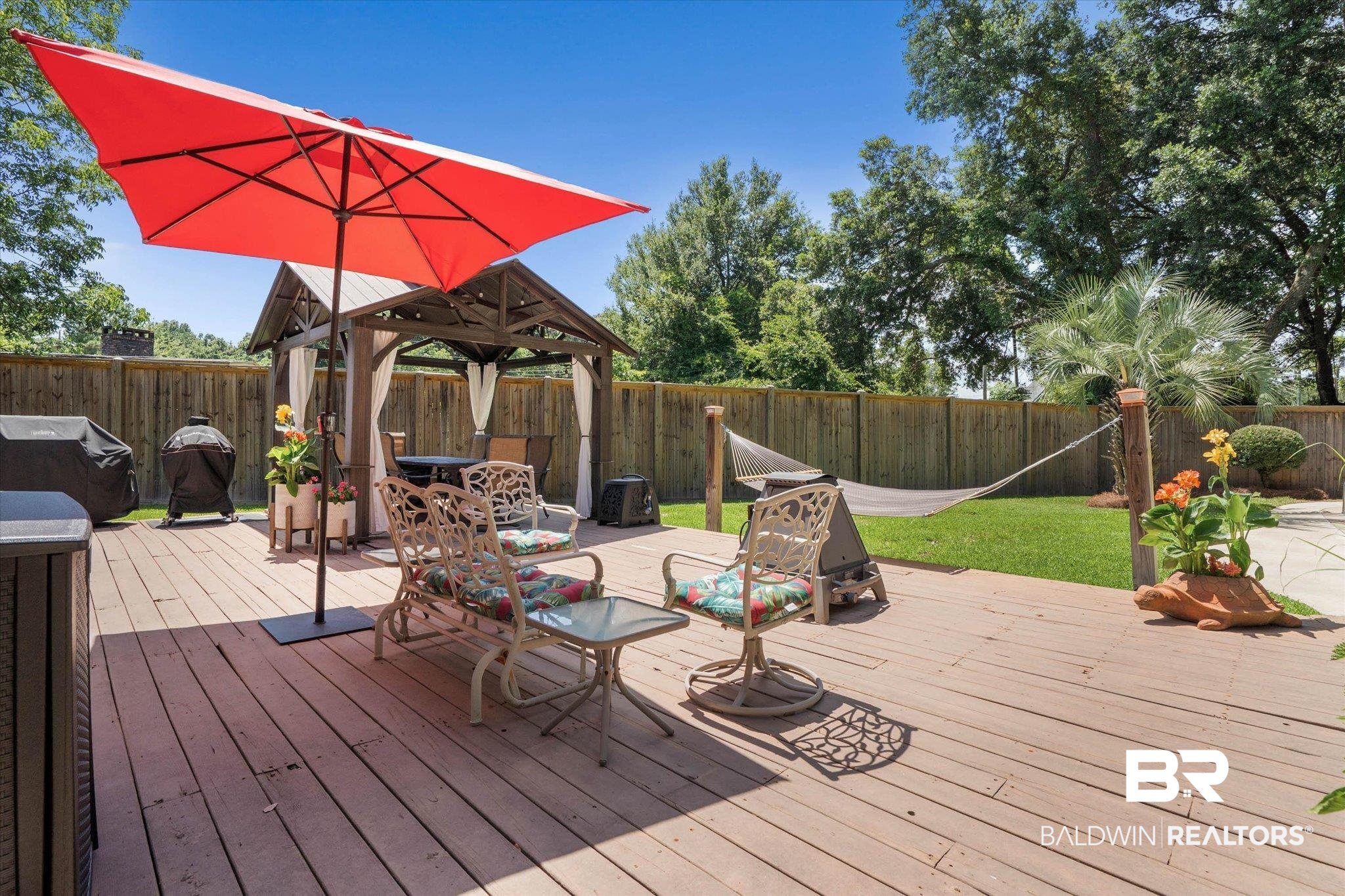 101 Ann Street Daphne, AL 36527 - Photo 27 of 38 Spacious wood-finish deck featuring a permanent gazebo with privacy curtains, a fixed hammock, and a privacy fence