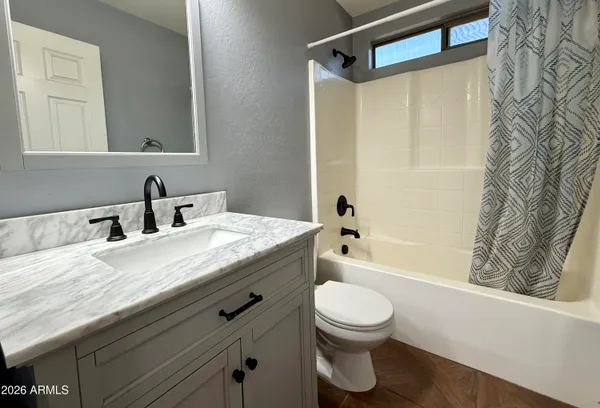 a bathroom with a granite countertop sink mirror vanity and toilet
