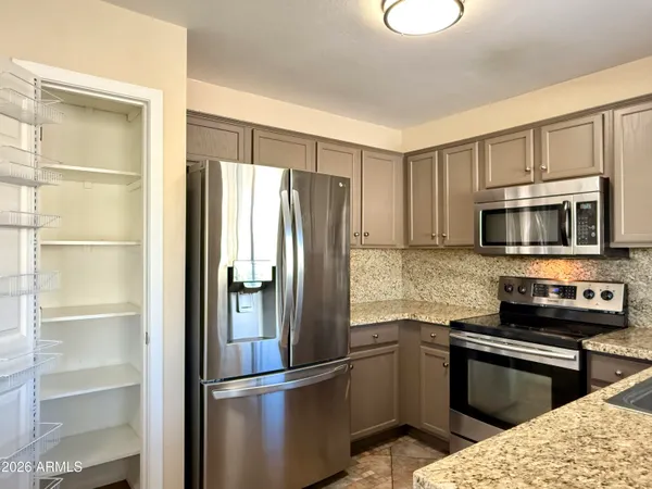 a kitchen with stainless steel appliances granite countertop a refrigerator stove and microwave